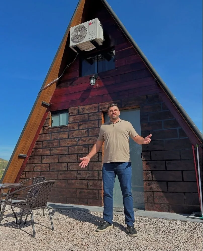 Foto de Mauro Henrique em frente à Cabana da Colina